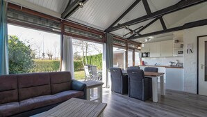 A modern kitchen with white cabinets and a wooden countertop. - Boerenslag-2 Bungalow, 5-guests Opposite Beach (Sint Maartensvlotbrug)