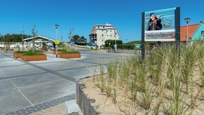 A modern building with a signboard advertising Rens Roosplein. - Studio in Groote Keeten by the Beach (Callantsoog)