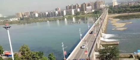 Eine Brücke über einem Fluss, im Hintergrund Gebäude.