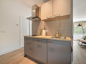 Una cocina moderna con estufa integrada, un lavamanos y un ventanal con vistas.