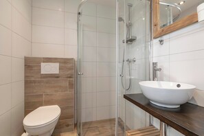 A modern bathroom with a glass-enclosed shower, a white sink, and a toilet. - Duinland 247modern Bungalow for 6 Guests (Sint Maartensvlotbrug)