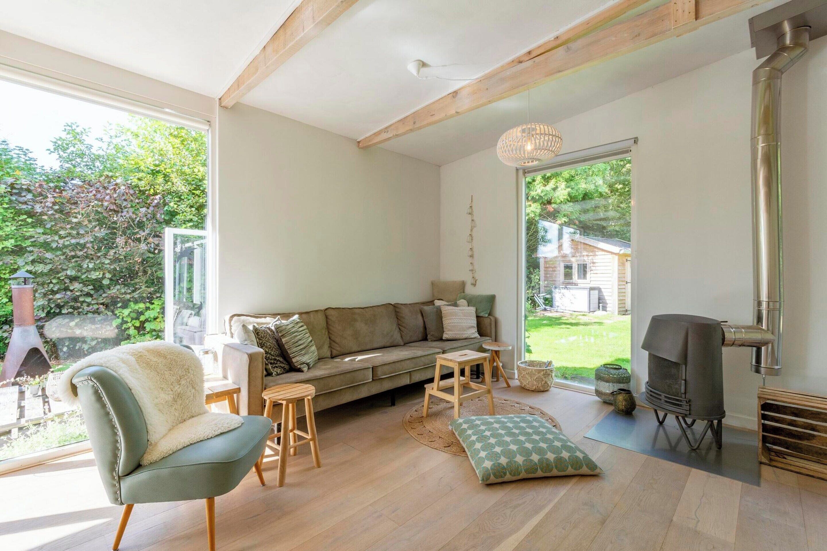 A cozy living room with a sofa, a chair, a small table, and a fireplace.