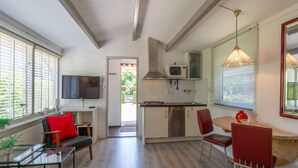 A modern kitchen with white cabinets, a microwave, and a stainless steel range hood. - Holiday Home in Callantsoog Near Beach (Callantsoog)