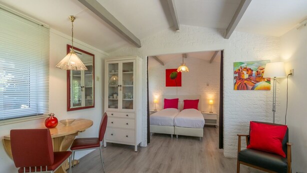 A compact room with a bed, a desk, a chair, a cabinet, and a painting on the wall. - Holiday Home in Callantsoog Near Beach (Callantsoog)