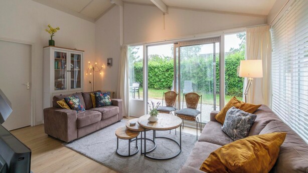 A modern living room with a sofa, armchairs, a coffee table, and a cabinet. - Family Home by the Dunes (Sint Maartensvlotbrug)