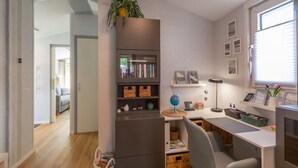 A modern kitchen with a built-in fridge, a dining area with a white table, and a view of the living room. - Garnekuul 49 Holiday Home in Callanstoog (Callantsoog)