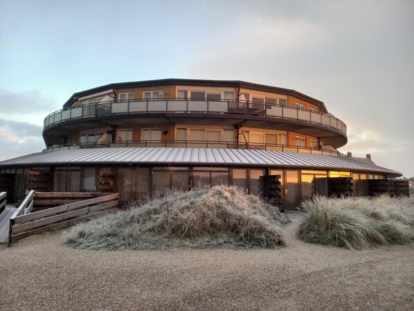 A multi-story, circular building with a flat roof and large windows. - Seaside Double Duyn Suites (Callantsoog)