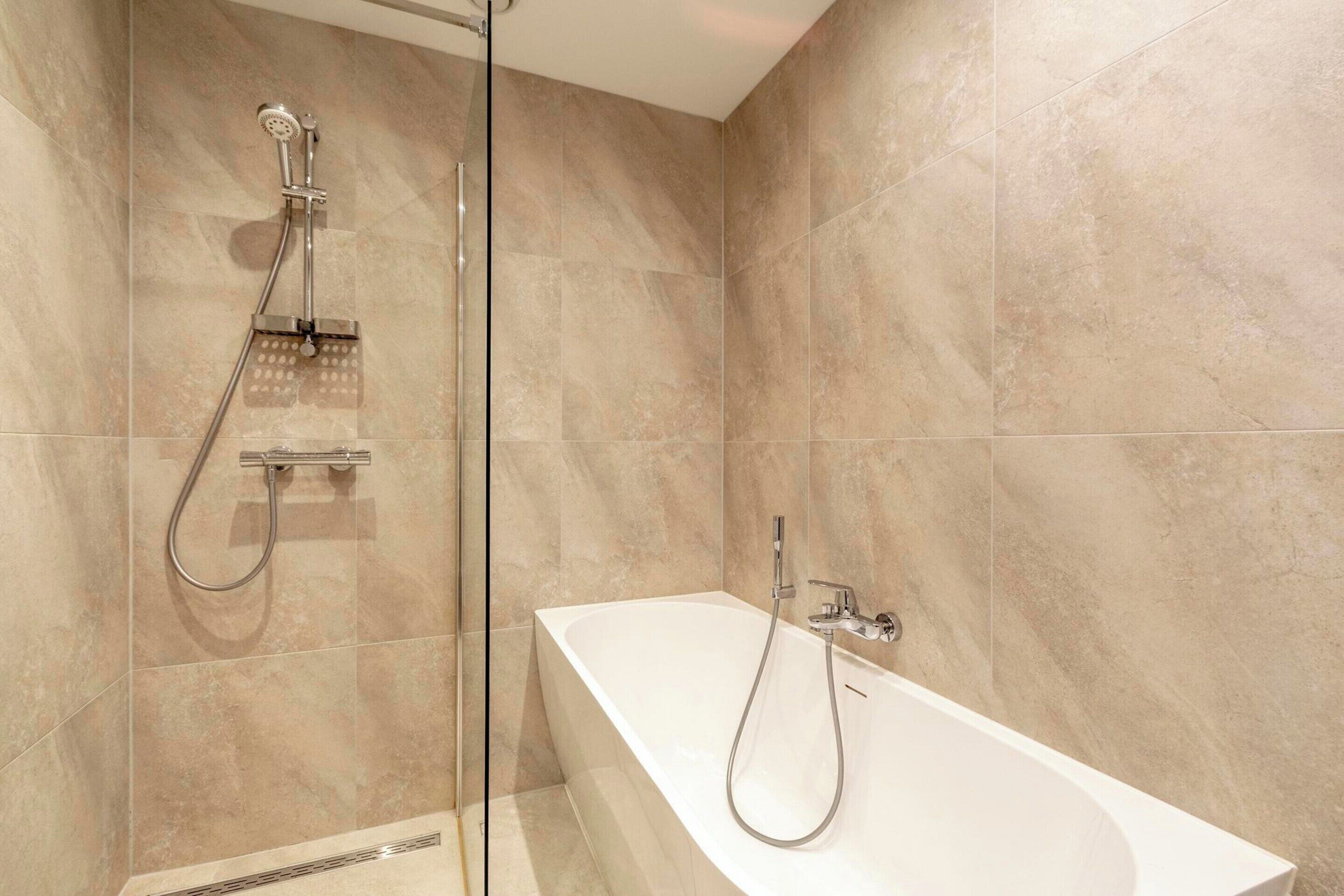 Un baño moderno con ducha acristalada y bañera independiente.