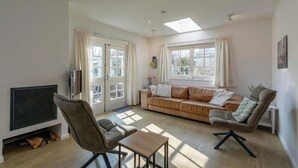 A living room with a sofa, chairs, a TV, and a fireplace.