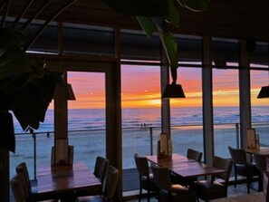 A restaurant with a view of the ocean at sunset. - Family Beach Getaway (Callantsoog)