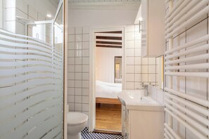 Une salle de bain moderne équipée d’une douche, de toilettes et d’un lavabo.