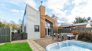 A modern house with a patio, a hot tub, and a fenced backyard. - Villa Near Sint Maartenszee Beach With Jacuzzi (Sint Maartensvlotbrug)