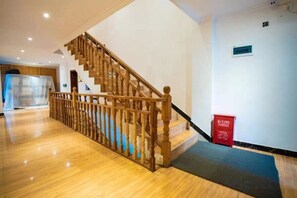 Un escalier en bois, doté d’une rampe, menant à l’étage supérieur.