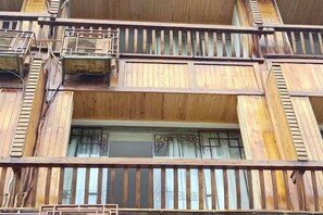 A multi-story building with balconies, railings, and windows. - Xijiang miao village listen to tao xuan hotel (Leishan)