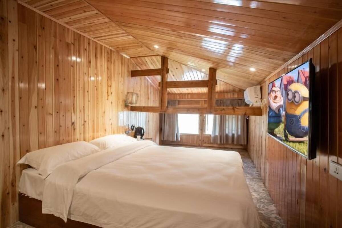 Ein Holzinnenraum mit einem Bett, einem Fernseher und einem Fenster.