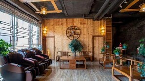 Une pièce avec un mur en bois, des fauteuils de massage, une table et des plantes en pot.