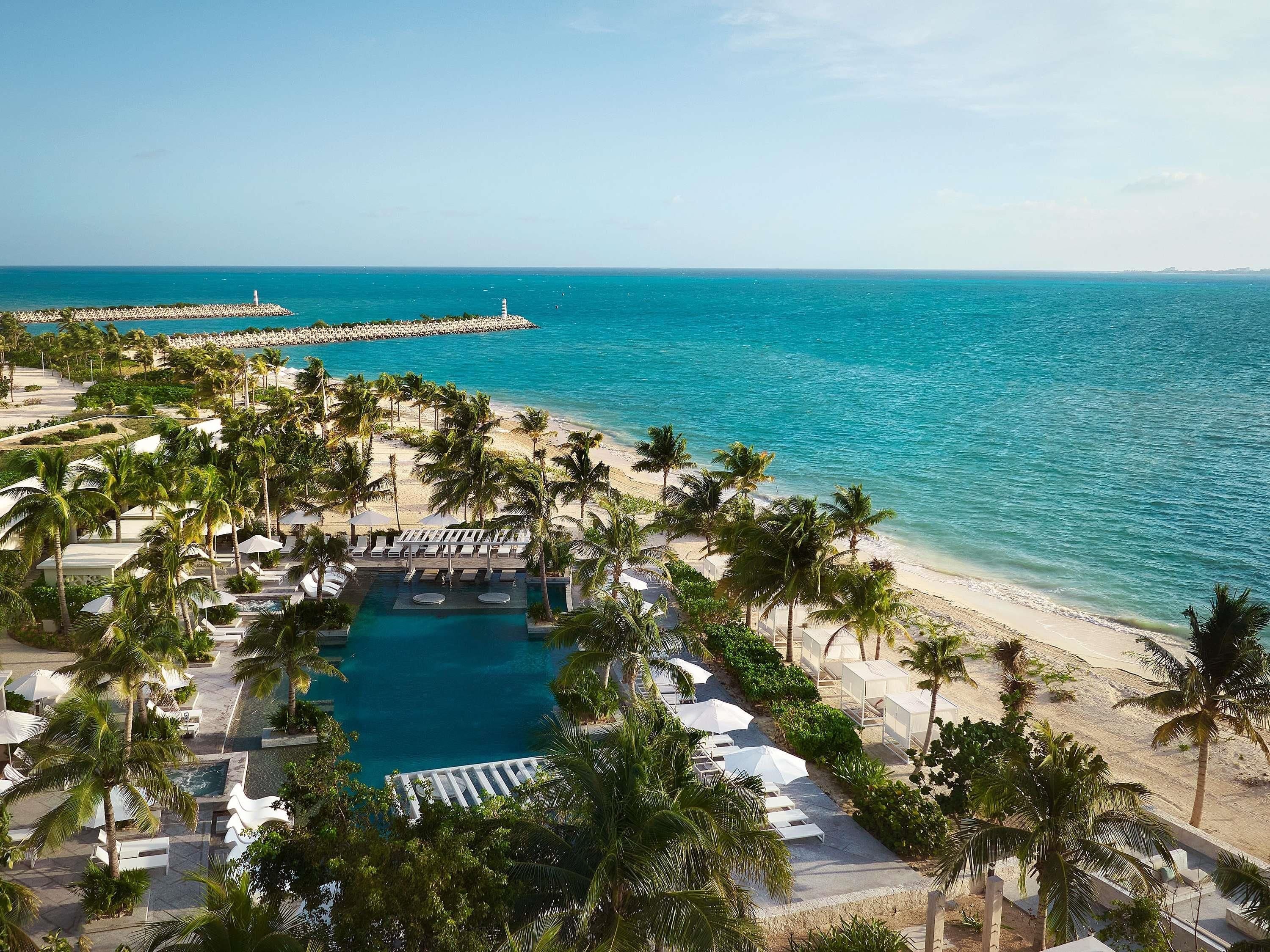 A resort with a pool, beach, and ocean view.