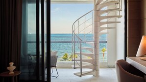 Una escalera de caracol conduce a un balcón con vista al mar.