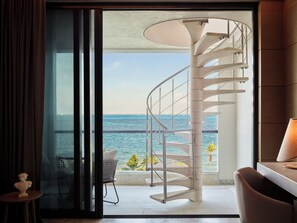 Una escalera de caracol conduce a un balcón con vista al mar.