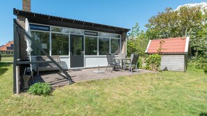 A modern house with a patio, a small shed, and a staircase leading to a deck. - De Zeester 4-person Holiday Home n De Koog (Callantsoog)
