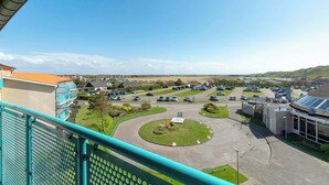 Un espace de stationnement doté d’un rond-point central, entouré de bâtiments et sous un ciel dégagé.