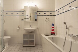 A bathroom with a toilet, sink, and bathtub. - Stunning Apartment Near sea (Julianadorp)