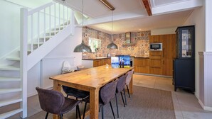 A modern kitchen with patterned backsplash, wooden cabinets, and a built-in oven. - Holiday Home in De Koog Near Beach (De Koog)