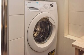 A front-loading washing machine with a control panel and a label indicating a 25% energy saving mode. - Holiday Home Groote Keeten Near Beach (Callantsoog)