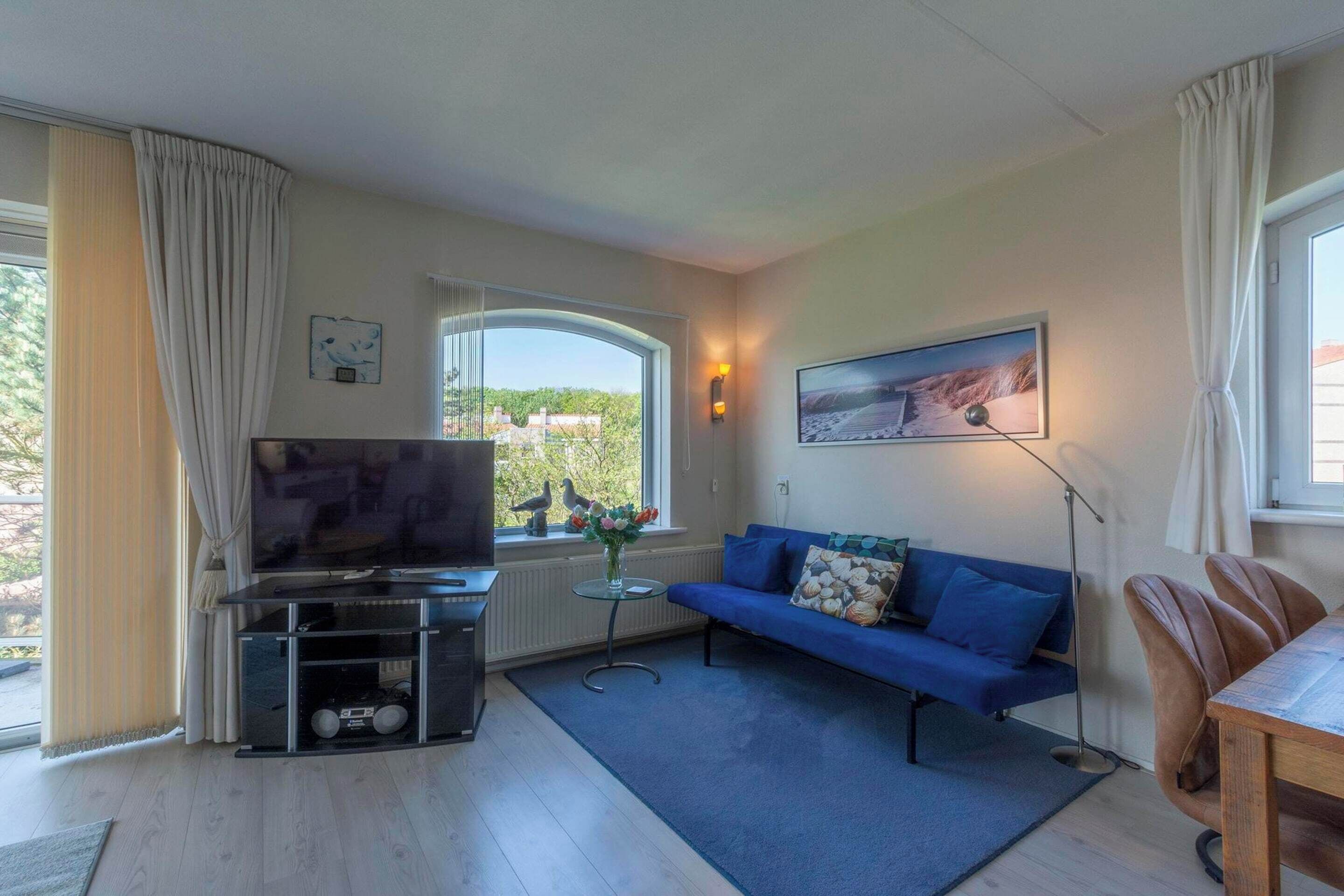 A living room with a TV, sofa, and dining table.