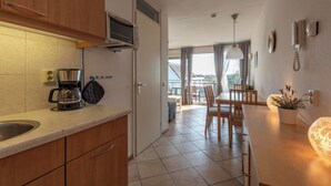 A kitchen with a coffee maker, a microwave, and a dining area with a table and chairs.