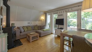Un salon confortable avec un canapé, un téléviseur et une table en bois.