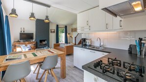 A modern kitchen with a central island, built-in cabinets, and a gas stove. - Yperhof 66 Holiday Home for 6 Guests on Cost (Julianadorp)