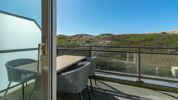 Un balcon avec une table et des chaises, offrant une vue sur le paysage.