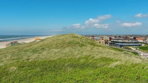 A coastal town with a prominent hill, beach, and buildings with varied architecture. - Wijde Blick 212 Apartment in Callanstoog (Callantsoog)