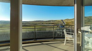 A balcony with a clear view of a hilly landscape and a road. - Wijde Blick 206 Apartment in Callanstoog (Callantsoog)