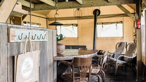 Un'atmosfera rustica con arredi in legno, un tavolo e sedie, un lampadario e un estintore appeso al muro.