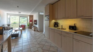 Eine moderne Küche mit Holzausstattung, einem Einbauofen und einer Kaffeemaschine.