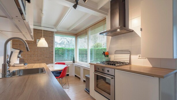 A modern kitchen with a built-in oven, a gas stove, and a stainless steel sink. - Wildrijk 83 Holiday Home Near Beach (Sint Maartensvlotbrug)