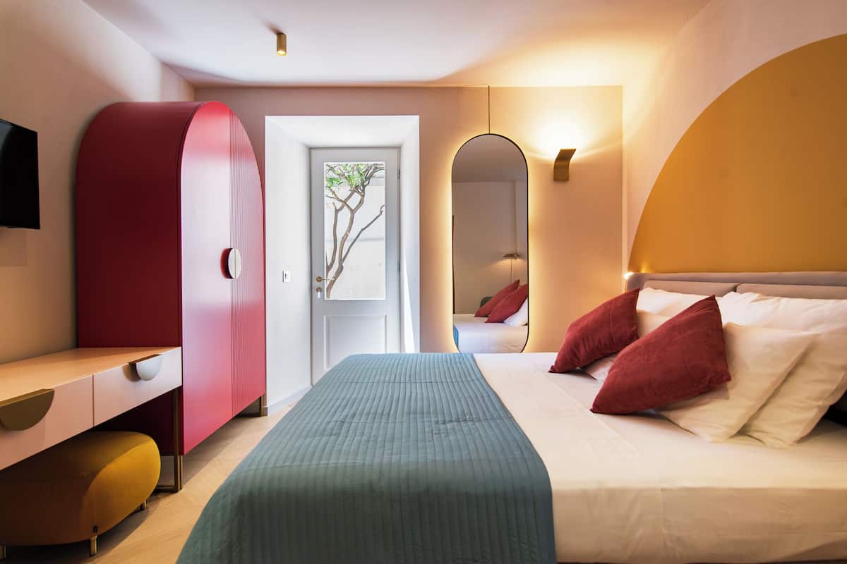 Un dormitorio moderno con cama, escritorio y armario.