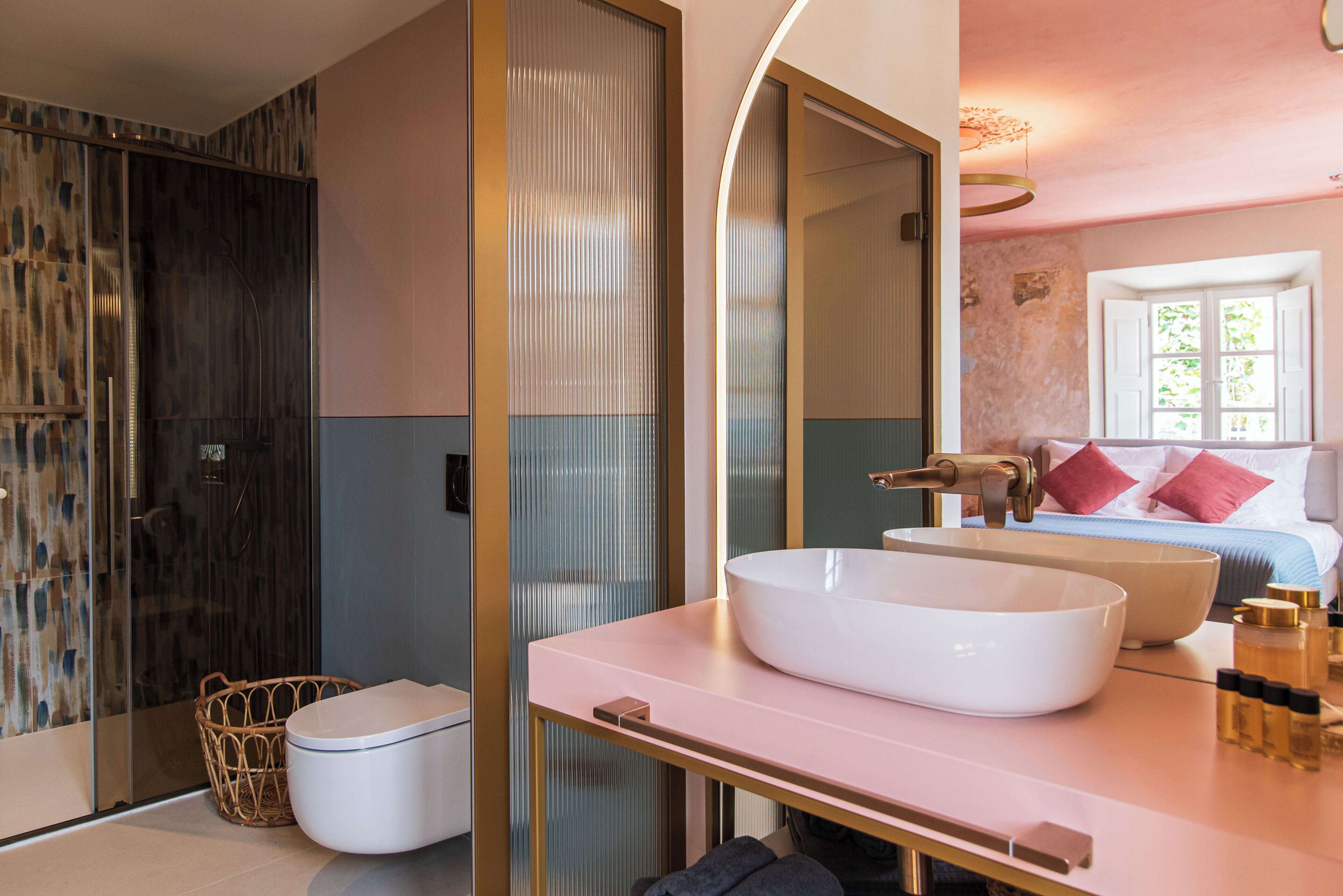 Un baño moderno con un lavamanos grande de color blanco, cabina de ducha con mampara de vidrio y zona de ducha separada.