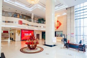 A spacious lobby with a reception desk, seating area, and a large window. - Longtang Hotel (Harbin)