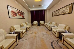 A conference room with a carpeted floor, arranged seating, and framed artwork on the walls. - Longtang Hotel (Harbin)