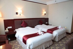 A hotel room with two beds, a desk, and two wall-mounted lamps. - Longtang Hotel (Harbin)