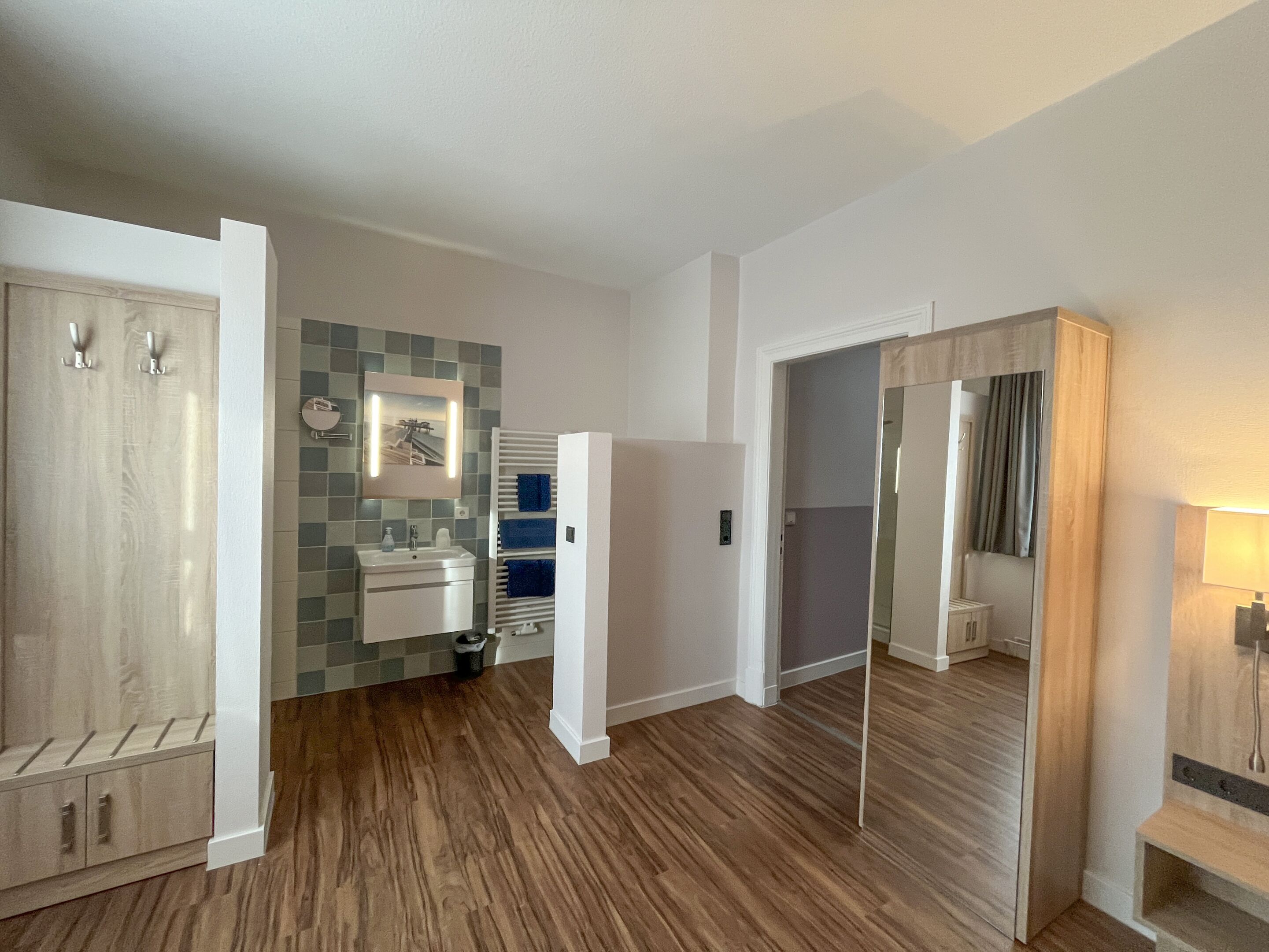 Un baño moderno con lavamanos, espejo y barra para toallas.