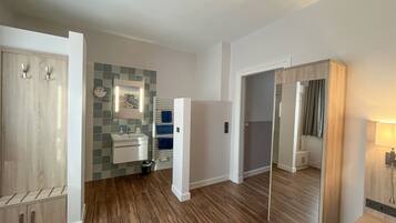 Un baño moderno con lavamanos, espejo y barra para toallas.