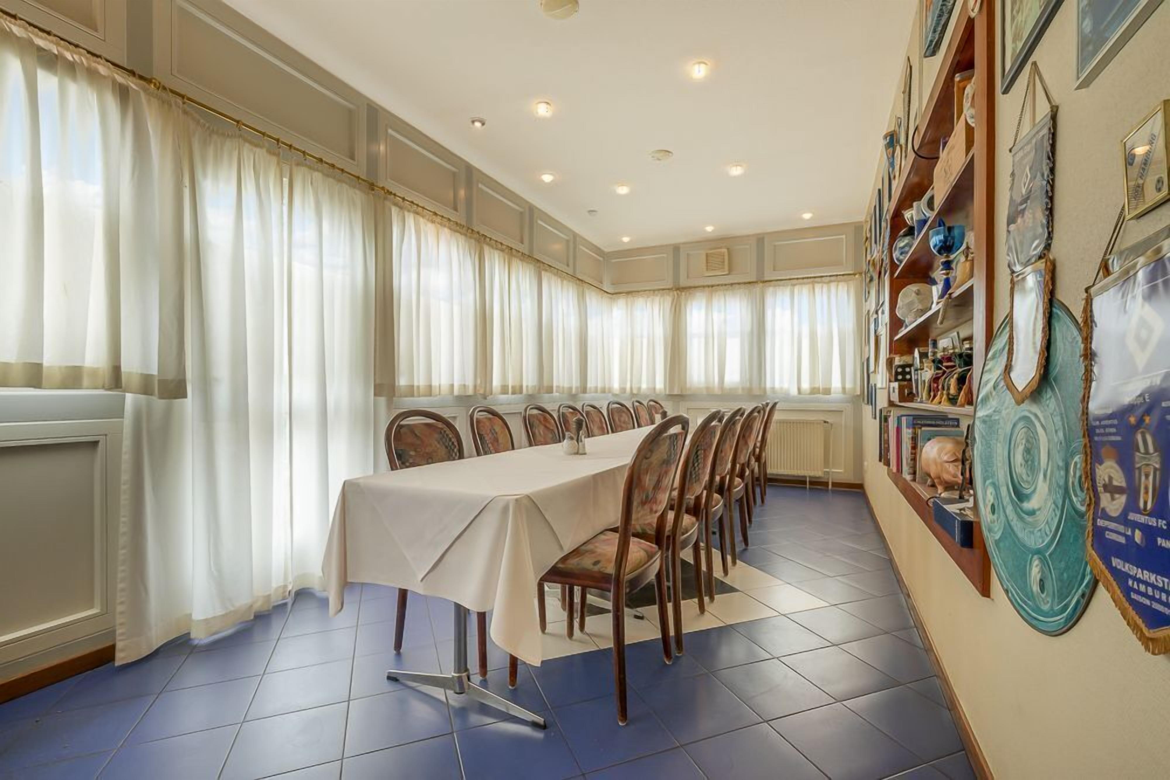 A conference room with a long table, chairs, and a wall with decorative items.