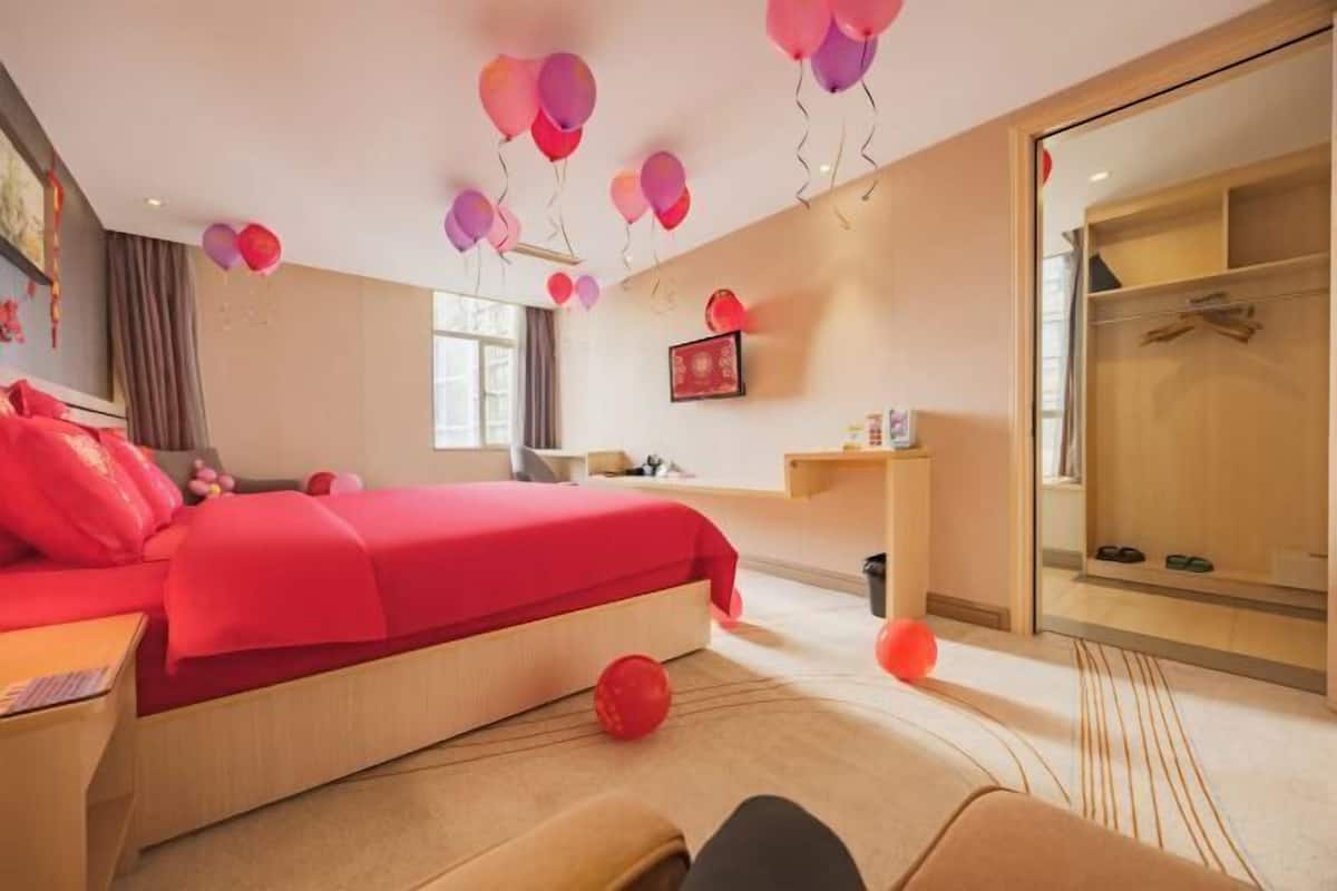 Una camera d'albergo con un letto, un comodino e uno specchio.