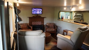A cozy living room with a fireplace, comfortable seating, and a television.