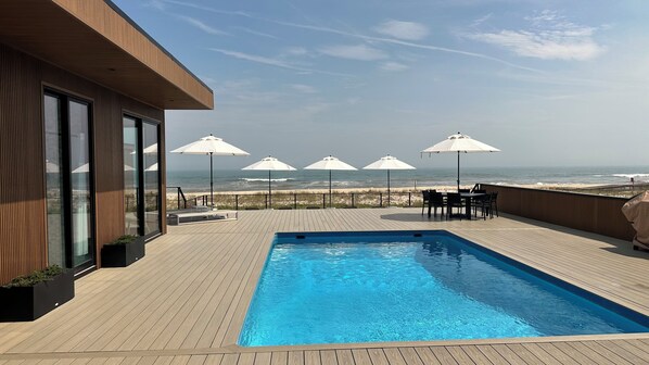 Una piscina en la azotea con vistas a la playa y al océano.