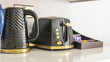 A coffee maker and a mug on a countertop.